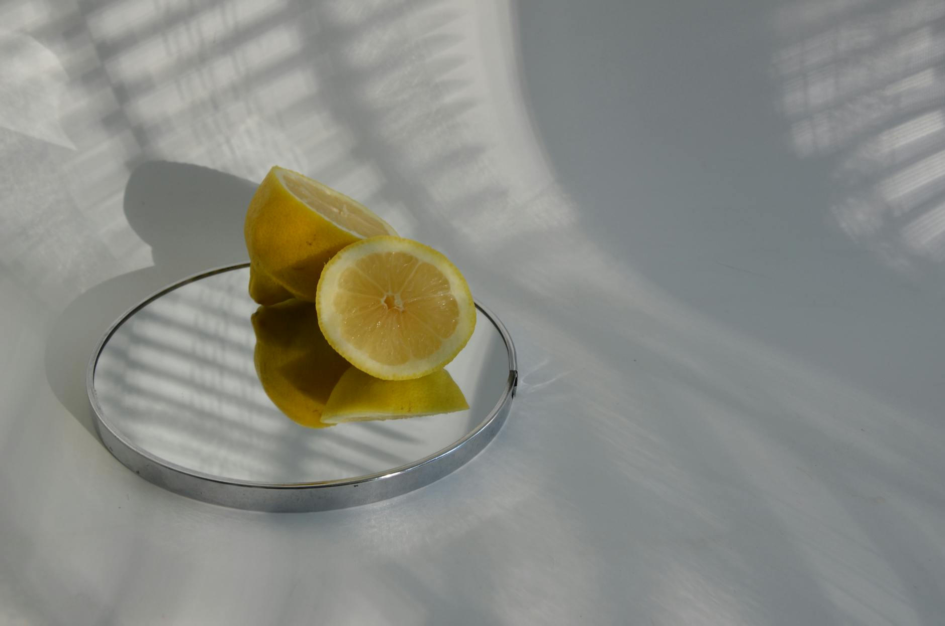 Blue vibrator surrounded by flowers and citrus slices on yellow background