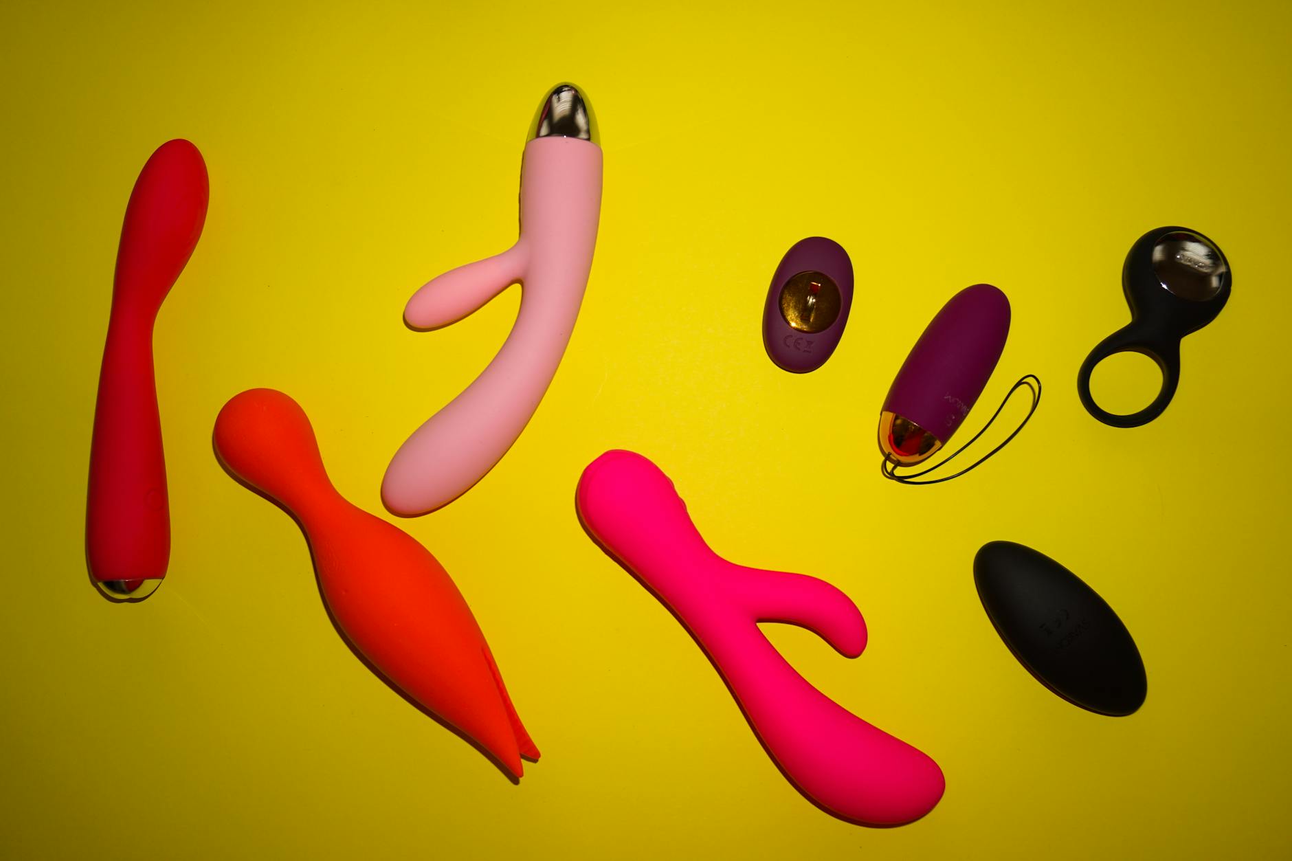 A blue silicone clitoral vibrator held in hand against a purple background, representing pleasure recovery tools